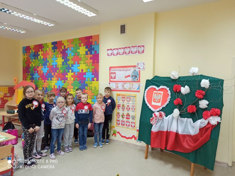 uczniowie SP Podwiesk na tle g...